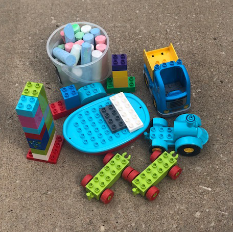 Example of chalk and legos used to build the lego city, including a lego boat, truch and train pieces.